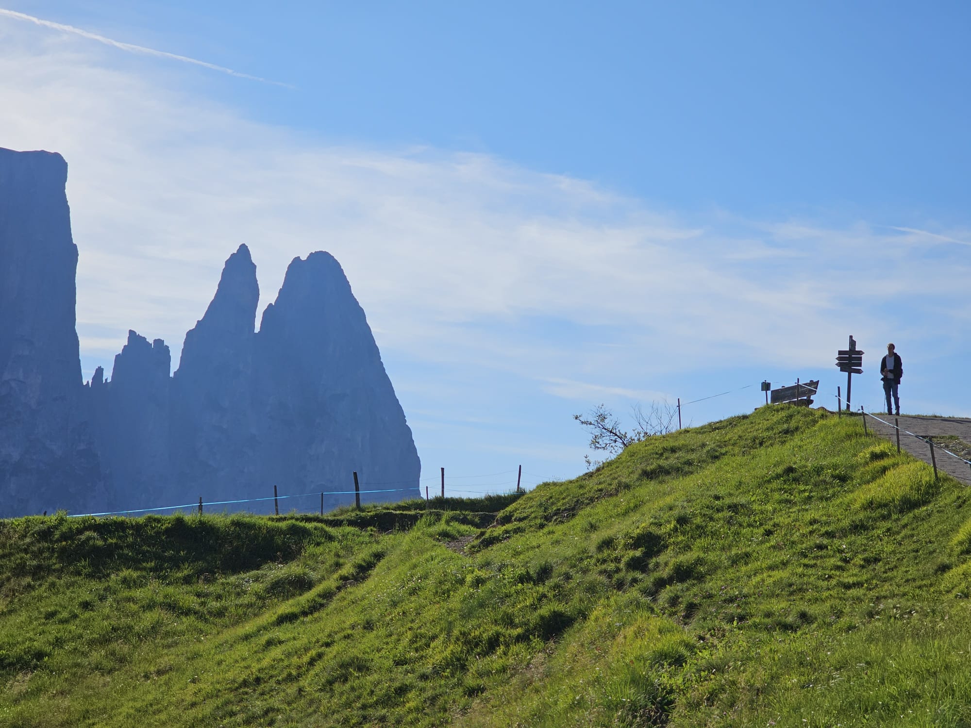 Lorenz Hartmann standing on a grassy ridge overlooking the Sella Towers in the Dolomites